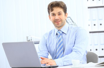 Closeup of employee in the office working on laptop computer